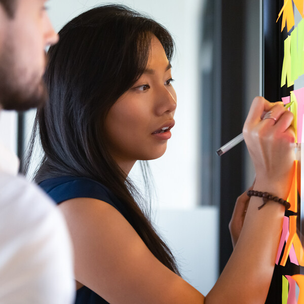 woman writing on post it notes